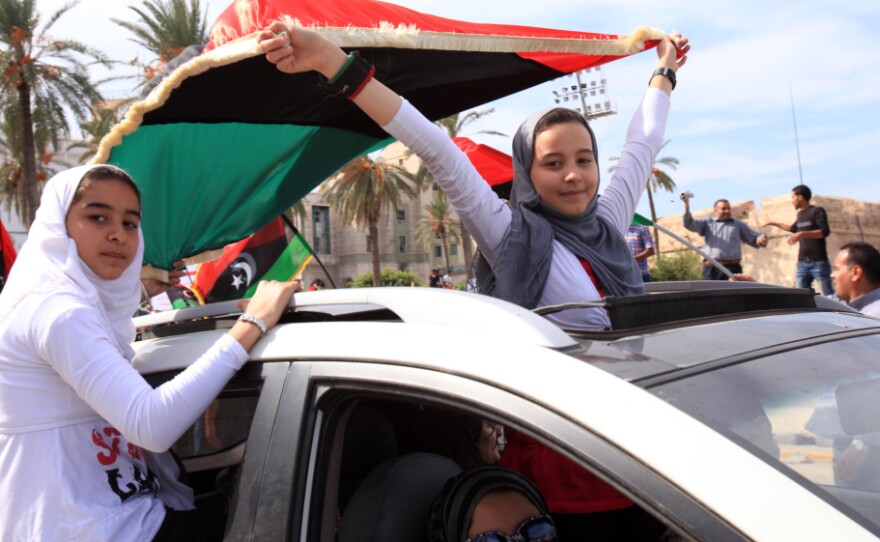 <p>Libyan girls wave flags of the Transitional National Council as they ride through the streets of Tripoli following word of Moammar Gadhafi's death. </p>