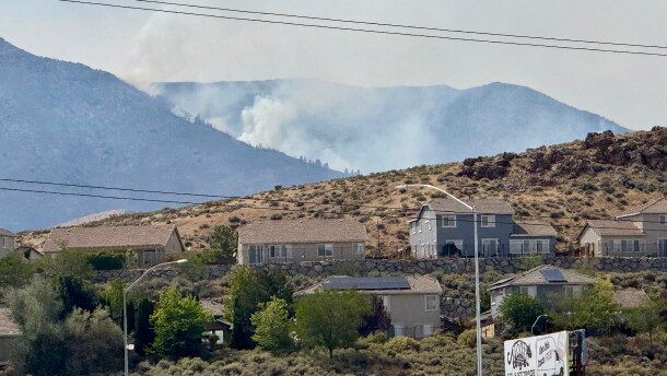 Smoke billows in the distance as a wildfire burns in Reno, Nev., Sunday, August 23, 2026. (AP Photo/Haven Daley)
