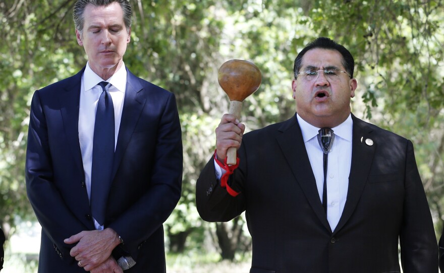 Gov. Gavin Newsom, left, bows his head as Assemblyman James Ramos opens a meeting with tribal leaders from around the state in 2019 in West Sacramento, Calif. In 2021, Ramos authored, and Newsom signed, a law to erect a monument to Native Americans in Sacramento outside the state capitol.