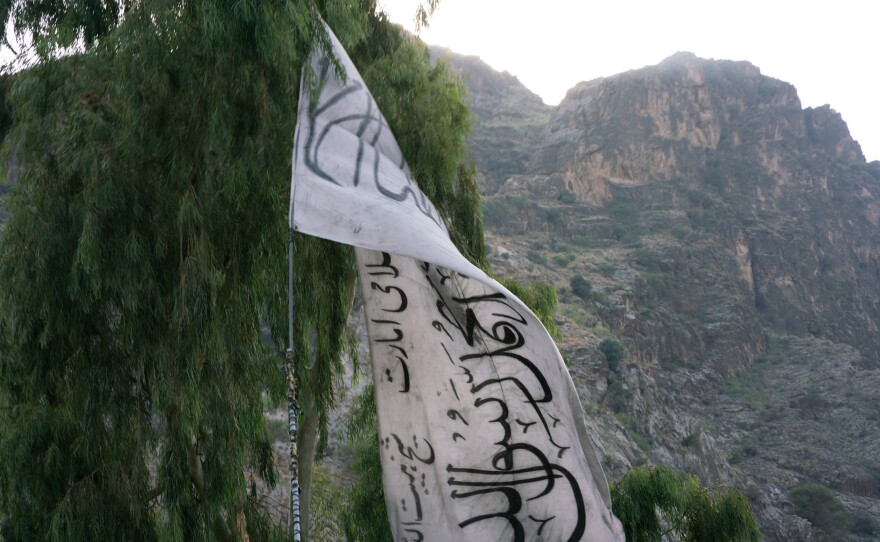The Taliban flag hangs on the Afghanistan-Pakistan border, backdropped by the mountains of Pakistan's Khyber Pakhtunkhwa province.