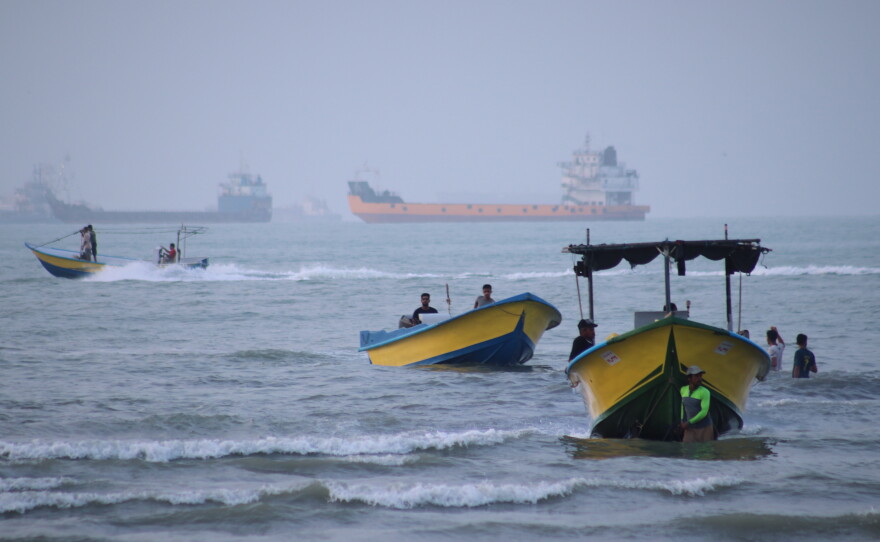 Small boats line the shore as cargo ships and other commercial vessels appear anchored in the Strait of Hormuz off Bandar Abbas, Iran, Monday, July 27, 2026.
