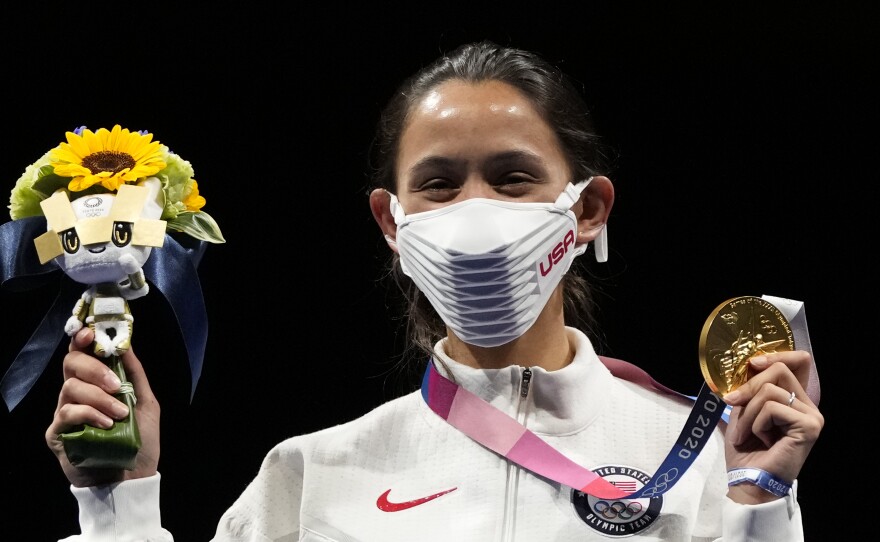 Gold medalist Lee Kiefer of the United States shows her medal and victory bouquet during the medal ceremony for the women's individual Foil final competition on Sunday at the 2020 Summer Olympics.