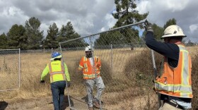 Construction workers unload fencing from a truck at the corner of Troy Street and Sweetwater Road on April 27, 2026.