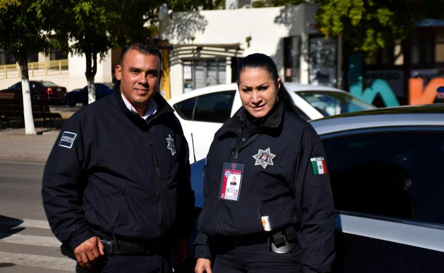 Hermosillo police Officers Luis Moreno and Cristina Garcia stand by a patrol car on Jan. 22, 2020.