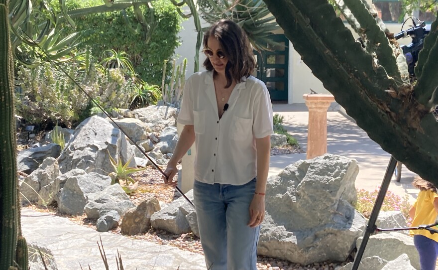 Herpetologist and biology professor Kinsey Brock holds a stick designed for catching lizards in a garden on the campus of San Diego State. July  15, 2024