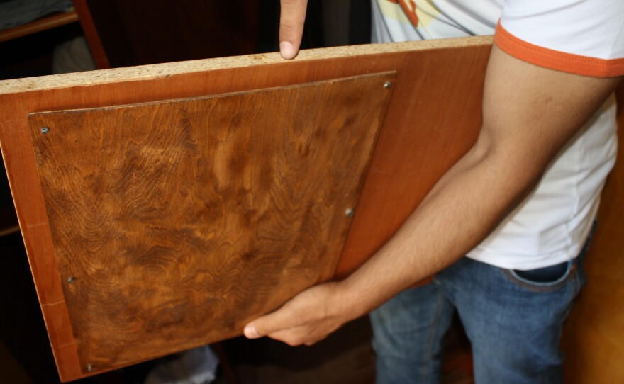 Currency and bank papers were hidden in this compartment beneath a shelf in an old wardrobe.