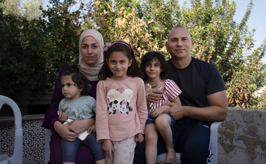Ma'in Zakarneh (right) with his wife, Yasmin, and daughters Salma, 1, Sarah, 5, and Maie, 3, at their home in Jenin.