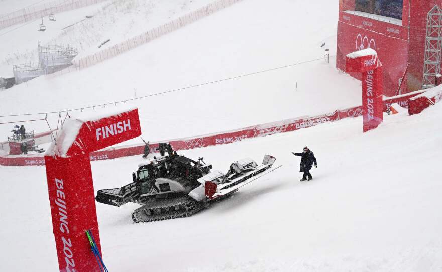 Workers clear snow from the finish line prior to the second run of the men's giant slalom. The second run was delayed due to the heavy snowfall.