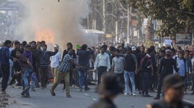 Protesters throw stones at security officers during a protest against the Citizenship Amendment Bill in Gauhati, India, on Wednesday.
