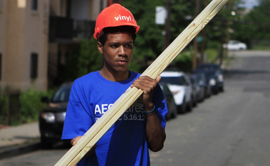 Domingo Williams, a participant in the Sasha Bruce Youthwork program, gathers wood to help rebuild a gutted house in the Southeast neighborhood of Washington, D.C.