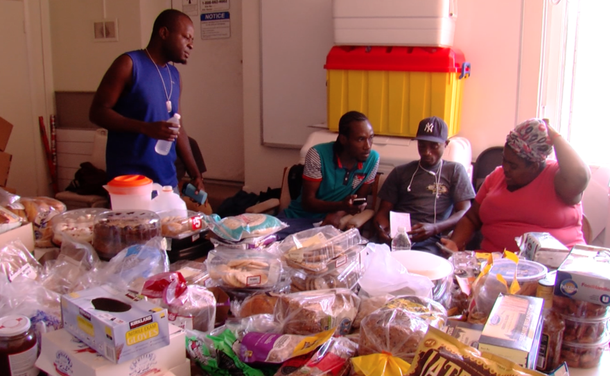 Haitians eat donated food at the United Methodist Christ Ministry Center, July 23, 2016. 