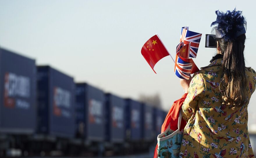 The train's arrival attracted a crowd of onlookers, including this woman who celebrated the new connection with both countries' flags.