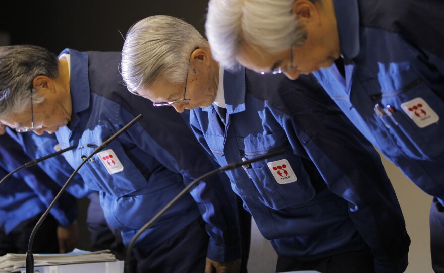 Tokyo Electric Power Co., (TEPCO) Chairman Tsunehisa Katsumata, center, and others bow before a news conference at the company's head office in Tokyo days after the nuclear disaster.