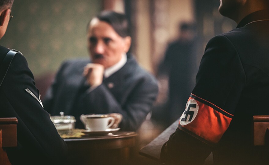 Drama reconstruction: Hitler in office meeting, swastika uniform.