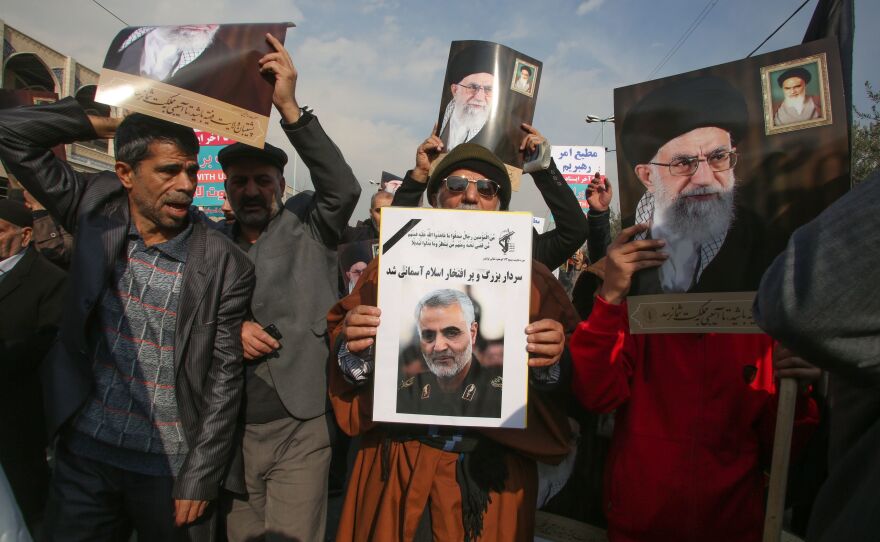Iranian demonstrators hold posters of slain Maj. Gen. Qassem Soleimani (center) and the country's supreme leader, Ayatollah Ali Khamenei, during a rally Friday in the capital, Tehran. The U.S. strike on the military leader in Baghdad has elicited warnings of retaliation from Iran.