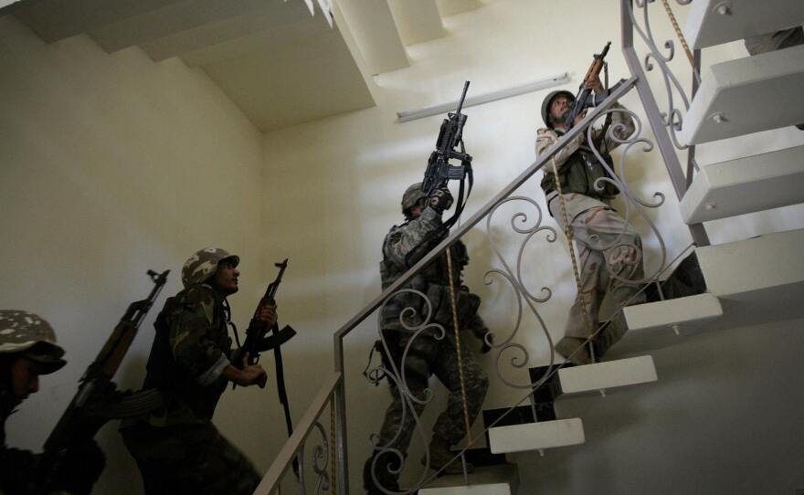 U.S. soldiers and Iraqi national police race up a staircase as they search a house in Baghdad in 2007. The U.S. surge in Iraq drove back Islamist radicals at that time. The gains were lost after the U.S. withdrew from Iraq in 2011, but the Americans have returned with an air campaign against the Islamic State.