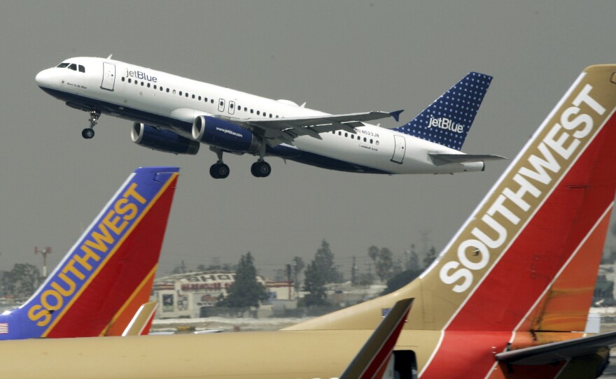 A JetBlue Airbus flies over a pair of Southwest Airlines' jets from Bob Hope Airport in Burbank, Calif., bound for New York's JFK airport, July 19, 2005.