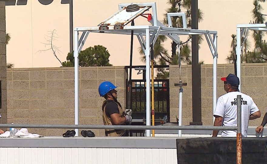 A firefighter candidate uses a pike to lift weights, simulating the force needed to prod open a ceiling at a fire scene, as part of the Candidate Physical Ability Test, at Miramar College, March 15, 2016.