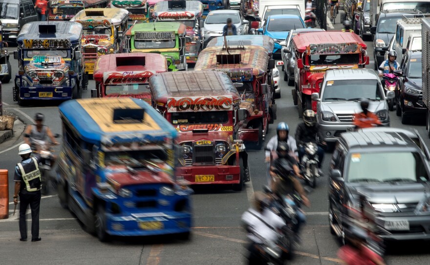 Jeepneys, often known in the Philippines as "King of the Road," join traffic on a busy street in Manila last May. Authorities are moving to phase them out, citing pollution and safety concerns.