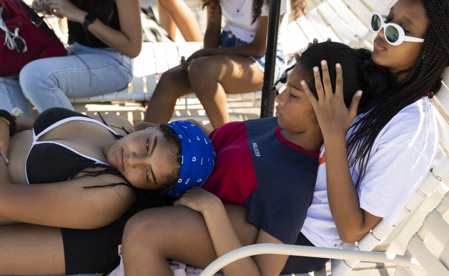 Sophia and Sylvie rest on Tewa at the pool.