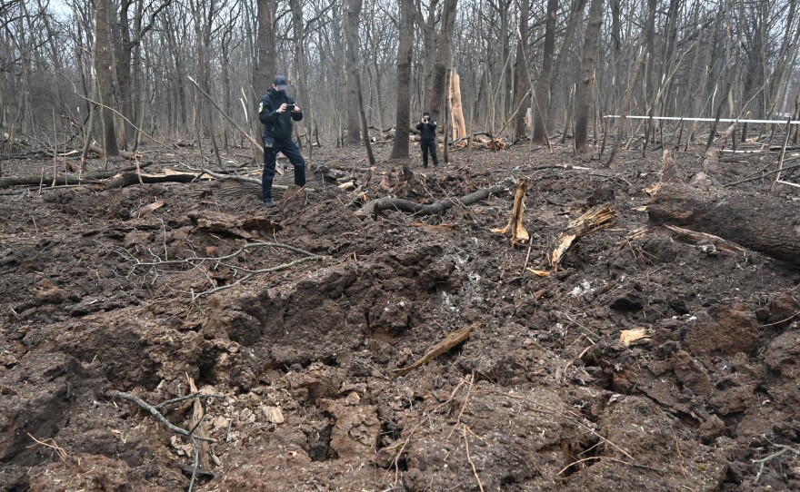 Kharkiv: Ukrainian police officers inspect the site of an explosion after a missile strike in the forest next to a medical complex.