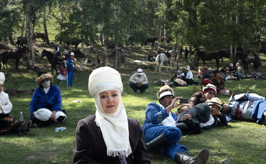 A Kyrgyz woman from the southern part of the country (center) and other onlookers watch the Nomad Game events.