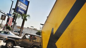 A Chrysler Jeep drives past a dealership in Los Angeles last year. The company, now part of Fiat, is trying to compete with other automakers that have deper pockets and more new cars to sell.