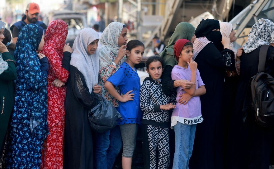 Palestinian women line up to buy fresh bread next to destroyed buildings at the Nuseirat refugee camp in the central Gaza Strip on Nov. 4, 2023.