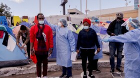 Health care workers from the city of Tijuana give migrants basic medical exams and screen migrants for COVID19 at there camp in the El Capparal plaza on Mexican side of the San Ysidro port of entry, March 12, 2021. 
