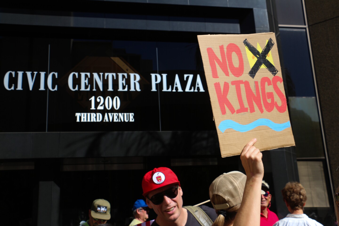 A protestor holds up a "No Kings" sign during a downtown San Diego rally on Oct. 18, 2025.