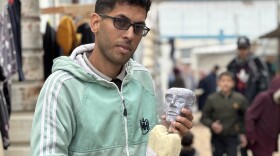 Yousef al-Hindi holds a puppet, also named Yousef, that he created using materials found in his camp in Rafah.