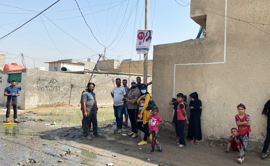 People stand on a street corner in a poor Baghdad neighborhood called Basateen. After the U.S. invasion in 2003, Washington backed the establishment of a governing structure in Iraq designed to share power among the country's different religious sects. But this has reinforced patronage and inefficiency in government, and a deteriorating quality of life for Iraqi citizens.