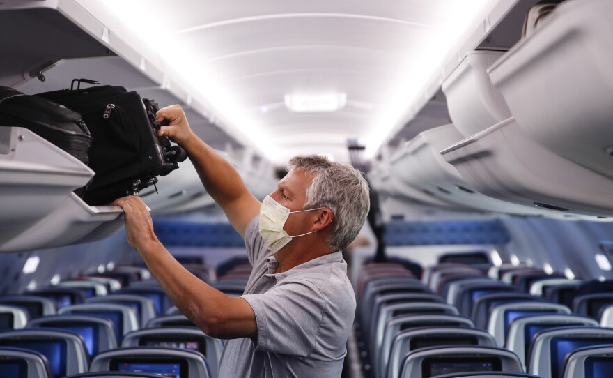 A passenger wears personal protective equipment on a Delta Air Lines flight after landing at Minneapolis−St. Paul International Airport in late May.