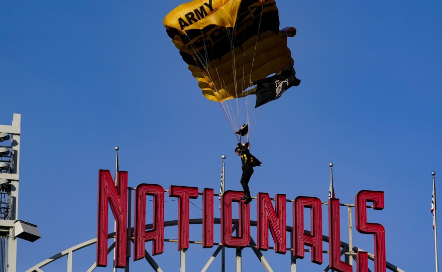 A member of the U.S. Army Parachute Team descends into National Park before a baseball game between the Washington Nationals and the Arizona Diamondbacks on Wednesday in Washington. The plane the team flew on entered restricted airspace on the way to the park, triggering an evacuation of the U.S. Capitol.