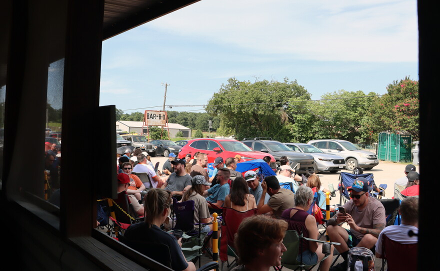 Customers sit in lawn chairs waiting for Goldee's BBQ to open on a summer Saturday in Fort Worth, Texas.
