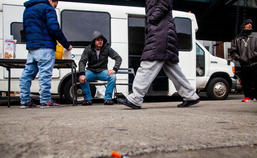 A bus run by the organization Prevention Point parks at Kensington and Allegheny avenues in Philadelphia to offer harm-reduction services to drug users in the area. Louis Morano (center), who was visiting the Prevention Point bus for the second time, sits outside and waits to be seen by Dr. Ben Cocchiaro.