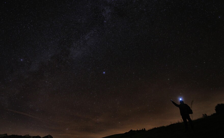 A photographer looks at the sky at night to see the annual Geminid meteor shower on the Elva Hill, in Maira Valley, near Cuneo, northern Italy on December 12, 2015.