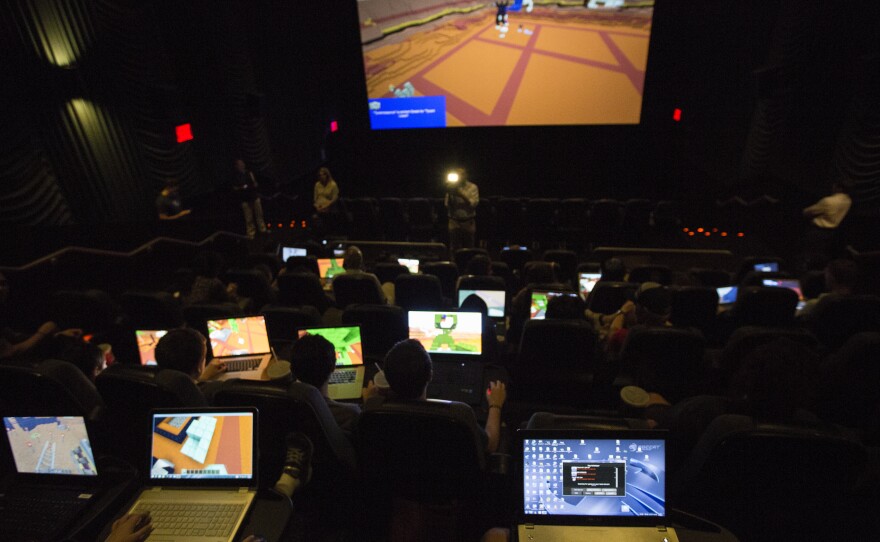 Gamers connect their laptops to the large movie theater screen to play Minecraft together for the Super League Gaming event.