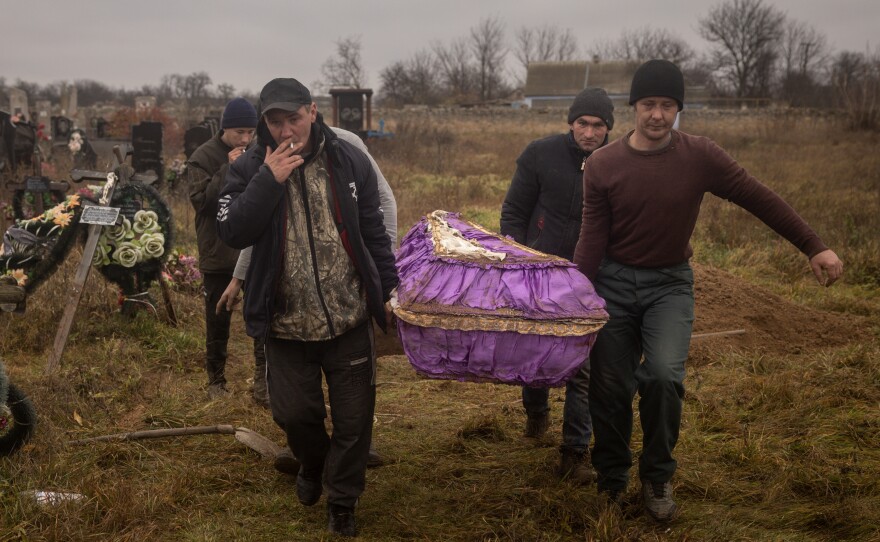 Residents of Kherson, Ukraine, carry the coffin of a 16-year-old girl on Nov. 29. The girl was killed by Russian forces.