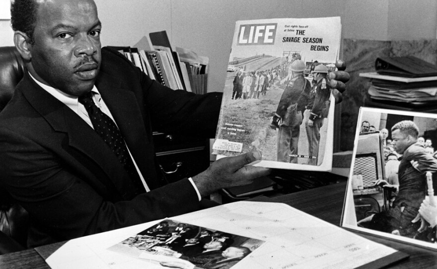 John Lewis, now a veteran Congressman, was beaten a number of times during his civil rights work in the 1960s. When he stepped of a bus in Rock Hill, S.C., in 1961, he says, he didn't expect a violent reaction. In this 1986 photo, he holds the 1965 issue of <em>Life </em> magazine that shows him leading the first Selma, Ala., civil rights march with Hosea Williams.