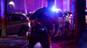 A police officer hangs yellow crime tape at Brown University in Providence, R.I., on Dec. 13, 2025, during the investigation of a shooting.