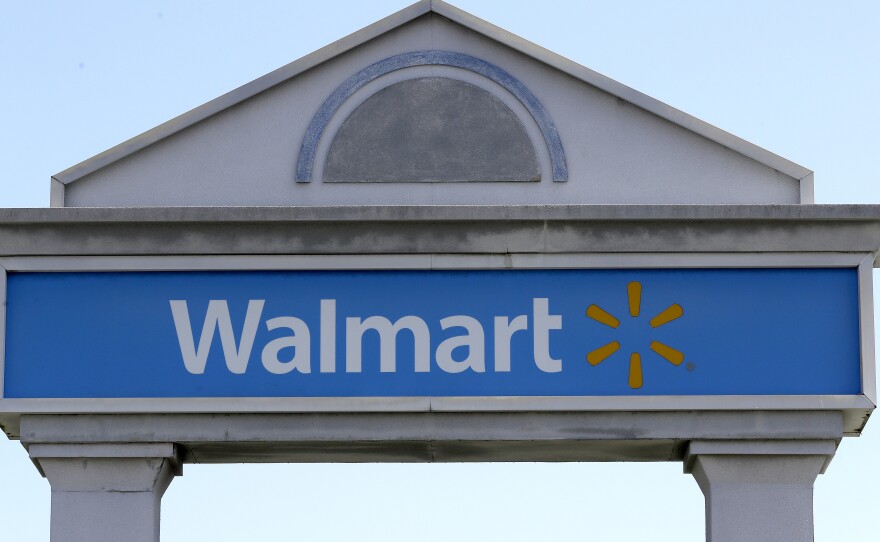 A Walmart logo forms part of a sign outside a Walmart store, Tuesday, Sept. 3, 2019, in Walpole, Mass. Walmart is going back to its folksy hunting heritage and getting rid of anything that's not related to a hunting rifle after a mass shooting this summer.