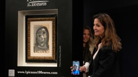 Peri Cochin, right, founder of "1 Picasso for 100 euros," speaks on the phone with the winner, Ari Hodara of Paris, next to the painting 'Head of a Woman' by Pablo Picasso, painted in 1941, after the raffle draw at Christie's in Paris, Tuesday, April 14, 2026, in support of Alzheimer's research.