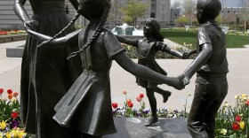 A statue representing womanhood — and women's role in raising children — is seen with the Mormon Temple in the background in Salt Lake City.