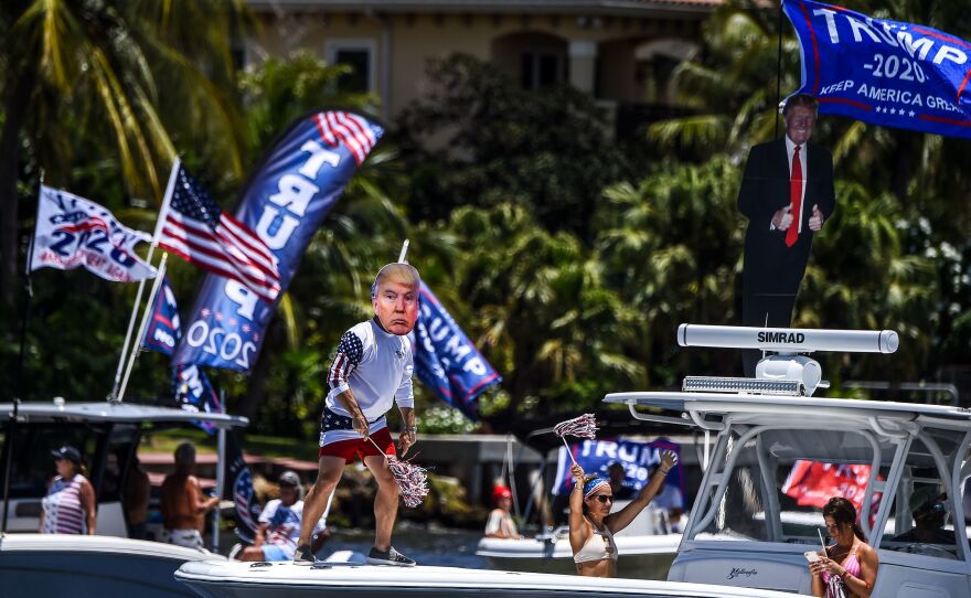 A supporter of President Trump wears a mask and dances during a boat rally to celebrate Trump's birthday in Fort Lauderdale, Fla., on Sunday.