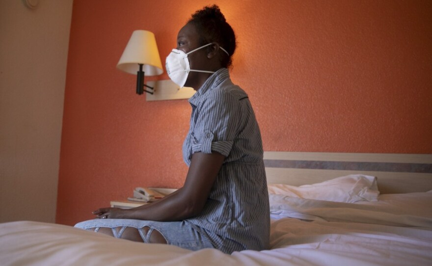 Jamie Burson sits on the bed of her motel room in Fairfield on Aug. 4, 2020. Burson, who has been homeless since being evicted in April, says she spends all of her time in her room with the curtains closed.