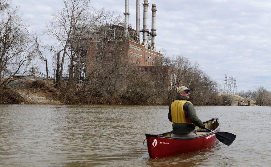 Mark Bishopric, a managing partner of Three Rivers Outfitters, paddles past the Duke Energy Dan River Steam Station in February 2014. Tens of thousands of tons of coal ash leaked into the river from a retaining pond below the steam station.