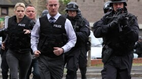 Annie Cabbot (Andrea Lowe), DCI Banks (Stephen Tompkinson) and police officers run to the scene of a crime. The Yorkshire countryside provides a striking and contrasting backdrop to these four chilling murder stories based on the "Inspector Banks" novels by Peter Robinson.