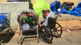 A man sits in a wheelchair near homeless encampments on 17th Street in San Diego's East Village, July 6, 2017.