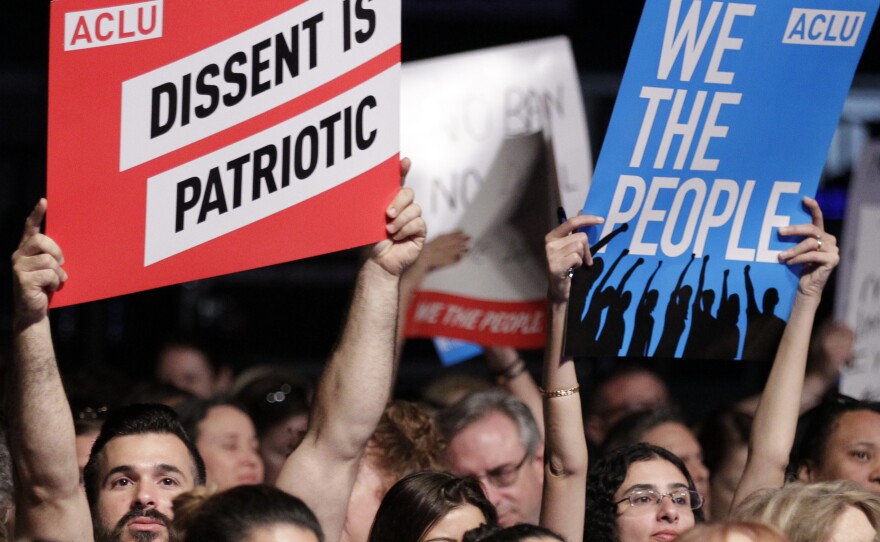 Protesters hold up signs during a meeting called "The Resistance Training" hosted by the American Civil Liberties Union in March.